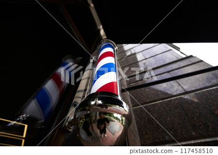 Barber pole reflecting a cityscape during cloudy weather Barber pole reflecting a cityscape during cloudy weather 117458510