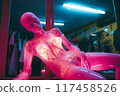 Mannequin in a dimly lit boutique showroom displaying neon glow and artistic design at night 117458526