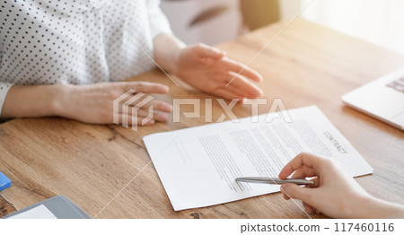 Business people discussing contract signing deal while sitting at the wooden table in office. Partners or lawyers working together at meeting. Teamwork, partnership, success concept Business people discussing contract signing deal while sitting at the wooden table in office. Partners or lawyers working together at meeting. Teamwork, partnership, success concept 117460116