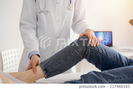 Doctor and patient are at the medical inspection in clinic. Orthopedic examines the knee of a young woman. Medicine concept Doctor and patient are at the medical inspection in clinic. Orthopedic examines the knee of a young woman. Medicine concept 117460165