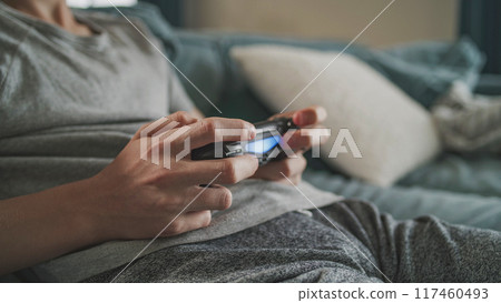 Close up hands of Caucasian young boy playing video game using wireless controller 117460493