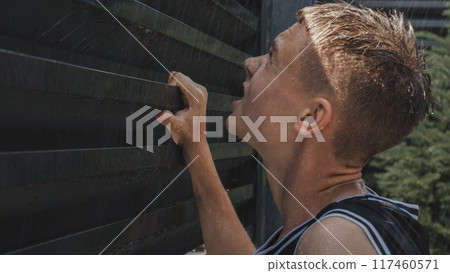 Tired and upset teenager breathing heavily and holding hands on the iron fence 117460571