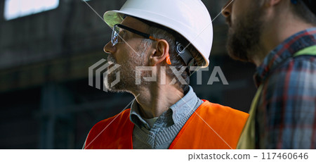 Close up of two industry technicians looking at industrial equipment Close up of two industry technicians looking at industrial equipment 117460646