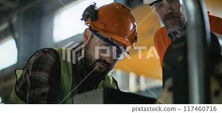 Male employee talks and shows industrial equipment to mature supervisor 117460716