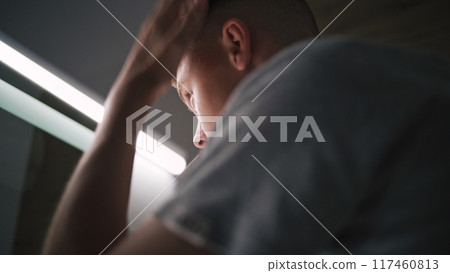 Teenager stands in bathroom and makes hairstyle in the morning 117460813