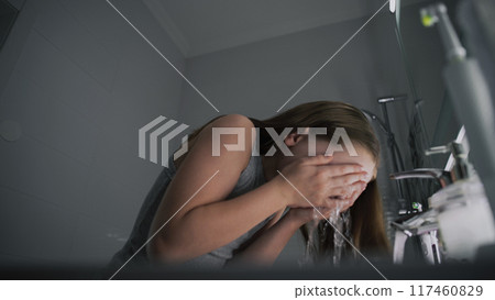 Adorable young girl comes in bathroom, washes her face Adorable young girl comes in bathroom, washes her face 117460829