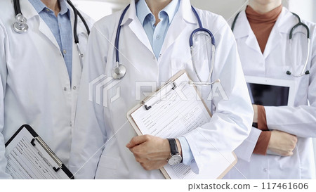 Group of doctors wearing white coats and stethoscopes standing with clipboards. Medical team at work 117461606