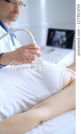 Doctor man using ultrasound equipment on the breast of a female patient. Mammary gland health. Medicine concept 117461859
