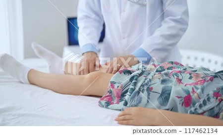 Doctor and kid patient. Orthopedist examining girl's knee in medical clinic. Medicine and health care Doctor and kid patient. Orthopedist examining girl's knee in medical clinic. Medicine and health care 117462134