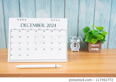 December Monthly desk calendar for 2024 year and alarm clock on table. December Monthly desk calendar for 2024 year and alarm clock on table. 117462772