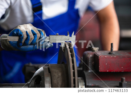 Engineering worker man wearing uniform safety working using vernier Engineering worker man wearing uniform safety working using vernier 117463133