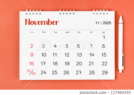November 2025 Monthly desk calendar for 2025 year and pen on red. 117464293