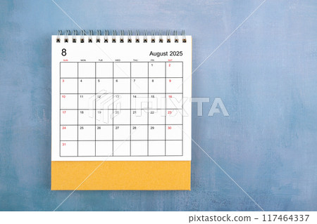 Directly above view of August 2025 desk calendar on blue wooden background. 117464337