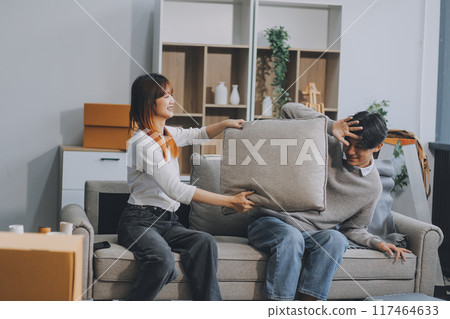 Happy asian young attractive couple man and woman sit on couch use tablet shopping online furniture decorate home in the living room at new house. Young married moving home shopper online concept. 117464633