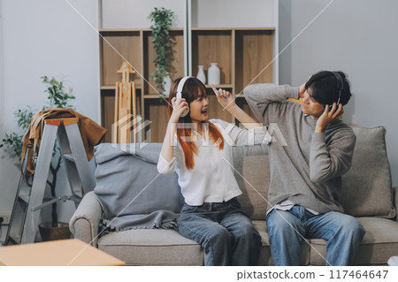 Asian Female discussing new project with male colleague. Young woman talking with young Asian man with financial on sofa in home office Asian Female discussing new project with male colleague. Young woman talking with young Asian man with financial on sofa in home office 117464647