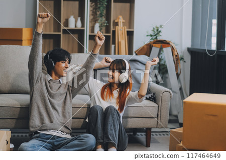 Asian Female discussing new project with male colleague. Young woman talking with young Asian man with financial on sofa in home office Asian Female discussing new project with male colleague. Young woman talking with young Asian man with financial on sofa in home office 117464649