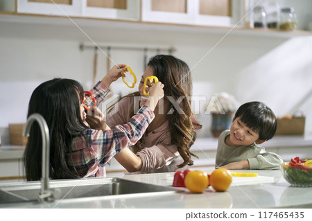 young asian mother having a good time with two children in family kitchen at home young asian mother having a good time with two children in family kitchen at home 117465435