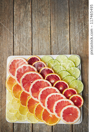 Fruit slice, diet and citrus with vitamin c benefits for healthy vegan nutrition and ingredients on plate. Natural product, food and grapefruit with orange for wellness and top view on wood table Fruit slice, diet and citrus with vitamin c benefits for healthy vegan nutrition and ingredients on plate. Natural product, food and grapefruit with orange for wellness and top view on wood table 117465495