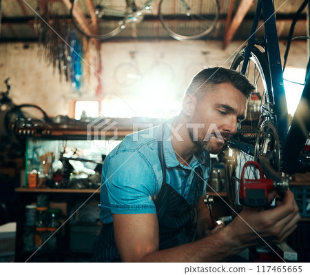 Bicycle technician, repair and working in shop with tyre, chain and tools for maintenance or cycling. Man, mechanic and bike in workshop as handyman for gear, inspection and safety with service Bicycle technician, repair and working in shop with tyre, chain and tools for maintenance or cycling. Man, mechanic and bike in workshop as handyman for gear, inspection and safety with service 117465665