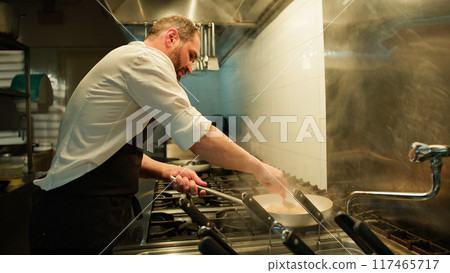 Chef Completing The Cooking Of The Dish  117465717