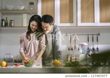young asian couple preparing meal in kitchen at home 117465977