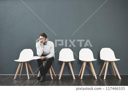 Waiting room, bored and businessman for recruitment, hiring and job interview in office. Chairs, think and male person as candidate of human resources, exhausted or impatient with paper in workplace 117466335
