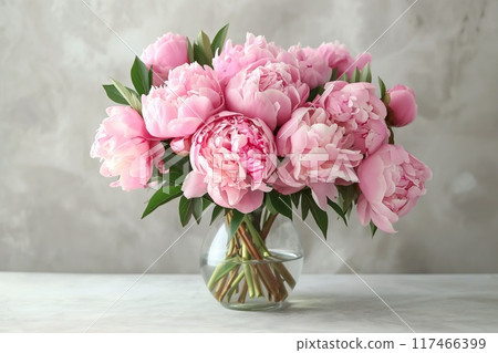 Beautiful peonies in vase on table against grunge background 117466399