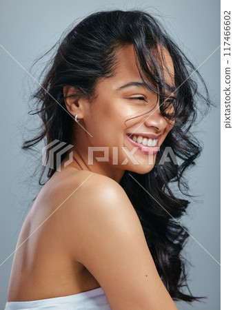 Hair care, happy and woman in studio with wind for beauty, cosmetics and confidence. Smile, pride and model girl for keratin treatment, breeze and glow by grey background for shampoo or shine Hair care, happy and woman in studio with wind for beauty, cosmetics and confidence. Smile, pride and model girl for keratin treatment, breeze and glow by grey background for shampoo or shine 117466602