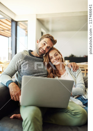 Portrait, happy couple and laptop in home for relax, bonding or connection online together. Man, woman and smile by computer on sofa for social media, news and streaming on website in living room 117466641