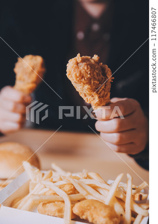 close up focus woman hand hold fried chicken for eat,girl with fast food concept 117466807