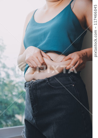 fat woman, fat belly, chubby, obese woman hand holding excessive belly fat with measure tape, woman diet lifestyle concept fat woman, fat belly, chubby, obese woman hand holding excessive belly fat with measure tape, woman diet lifestyle concept 117466845