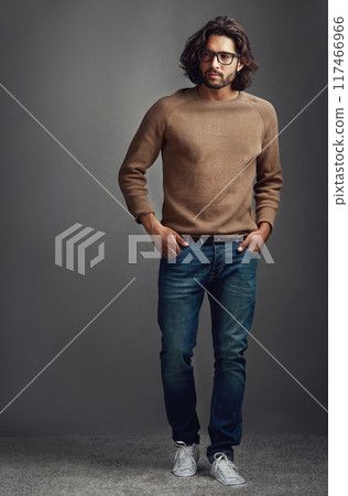 Thinking, serious man and fashion for portrait in studio, ideas for elegant style of comfortable jeans clothes. Serious, male person and trendy jersey, glasses or hands in pocket on grey background 117466966