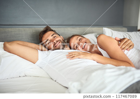 Smile, couple and portrait relax on bed in morning, peace or support for marriage commitment at house. Love, woman and man with embrace care, relationship romance or wake up together on vacation 117467089