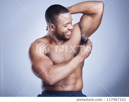 Black man, deodorant and apply in studio for beauty, body care and armpit for grooming on blue background. Person, hygiene and underarm for aroma or fresh scent, clean smell and topless for skincare Black man, deodorant and apply in studio for beauty, body care and armpit for grooming on blue background. Person, hygiene and underarm for aroma or fresh scent, clean smell and topless for skincare 117467102