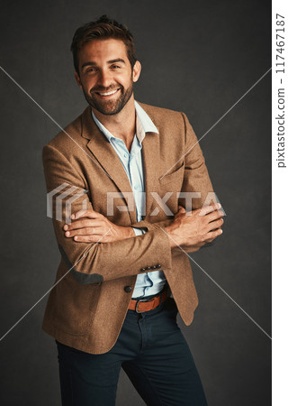 Confident, fashion and man for portrait in studio with stylish, trendy and elegant smart suit as Professor. Smile, male person and arms crossed in designer outfit with pride on grey background 117467187