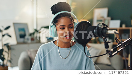 Podcast microphone, headphones and black woman talking for broadcast with audio recording and hosting show. Gen z, African girl and radio dj with virtual interview in home studio for online audience Podcast microphone, headphones and black woman talking for broadcast with audio recording and hosting show. Gen z, African girl and radio dj with virtual interview in home studio for online audience 117467261
