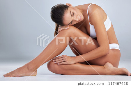 Woman, legs and soft skin in studio for epilation, underwear and hair removal on blue background. Female person, mockup space and waxing or lingerie for glow, grooming and cosmetics or dermatology Woman, legs and soft skin in studio for epilation, underwear and hair removal on blue background. Female person, mockup space and waxing or lingerie for glow, grooming and cosmetics or dermatology 117467428