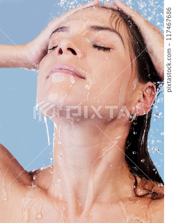 Shower, water and woman washing hair for shampoo, cosmetics and wellness cleaning or conditioner. Female person, haircare and rinsing scalp in studio blue background for skin care or morning routine 117467686