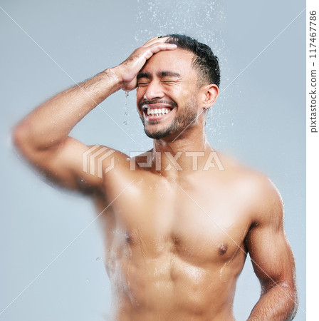 Man, shower and water on body for cleaning, skincare and wash on white studio background with smile. Male person, happiness and hygiene with clear liquid for facial, wellness or self care in bathroom 117467786