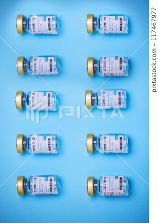 Medical, Covid vaccine and bottle in studio, innovation in health care for pandemic. Blue background, glass container and medicine with research for virus, chemistry development for human wellness Medical, Covid vaccine and bottle in studio, innovation in health care for pandemic. Blue background, glass container and medicine with research for virus, chemistry development for human wellness 117467977