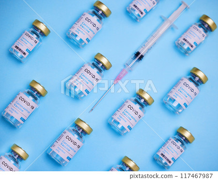Healthcare, syringe and glass bottle of vaccine by blue background, treatment or illness prevention. Medical, insulin and injection for disease, coronavirus or diabetes for immune wellness in studio Healthcare, syringe and glass bottle of vaccine by blue background, treatment or illness prevention. Medical, insulin and injection for disease, coronavirus or diabetes for immune wellness in studio 117467987