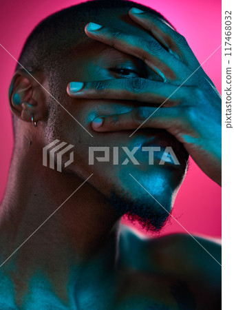 Creative, portrait and peeking in studio with hand, black man and neon light for art deco and mystery. Cosmetics, male model and eye for abstract, vaporwave and aesthetics by pink background 117468032