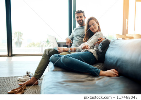 Portrait, happy couple and laptop in living room for relax, support nad connection for love together. Man, woman and smile by computer in home for social media, news and streaming on website on sofa 117468045