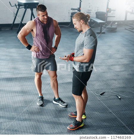 Fitness, gym accountability and man talking to client for training progress, coaching review and healthy routine. Personal trainer, workout tips or exercise schedule discussion, wellness and guidance 117468169