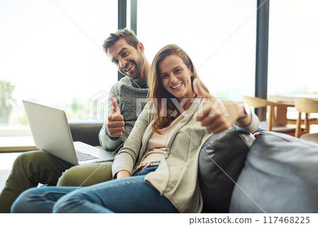Portrait, thumbs up and happy couple on laptop on sofa in living room for success, support or excellence. Man, woman and like hand sign with computer for winner, emoji or social media review in home Portrait, thumbs up and happy couple on laptop on sofa in living room for success, support or excellence. Man, woman and like hand sign with computer for winner, emoji or social media review in home 117468225