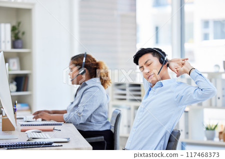 Stretching, stressed and tired call centre agent suffering from burnout, backache or being overworked. Lazy, bored and exhausted customer service representative feeling sleepy and listening to client 117468373