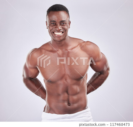 Portrait, abdomen muscle and black man for fitness with towel, exercise and sports training in studio. African bodybuilder, male person and strong body for wellness or health by white background 117468473