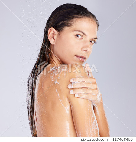 Woman, shower and soap in studio portrait for washing, clean and care for cosmetics or hygiene. Female person, skincare and foam on white background, water and refreshing liquid for routine pamper 117468496