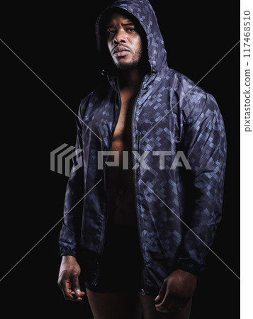 Black man, portrait and hoodie in studio for exercise, strong bodybuilder or training for wellness. Male athlete, dark background or confidence for workout, clothes with muscle for gym sport 117468510