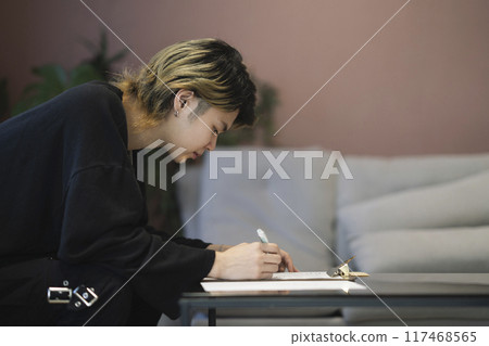 Young man filling out a document, profile 117468565